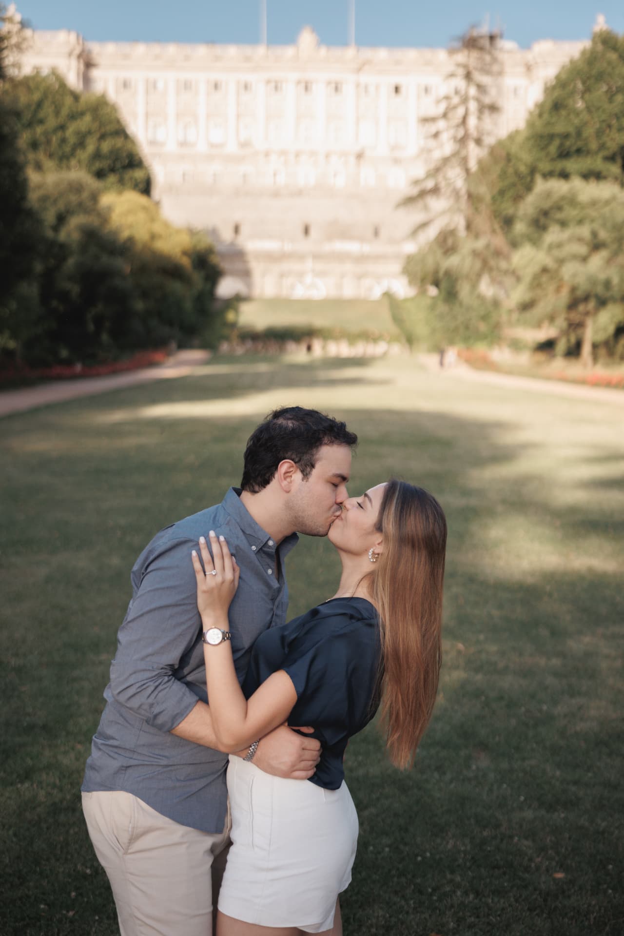 Los novios besándose frente al palacio